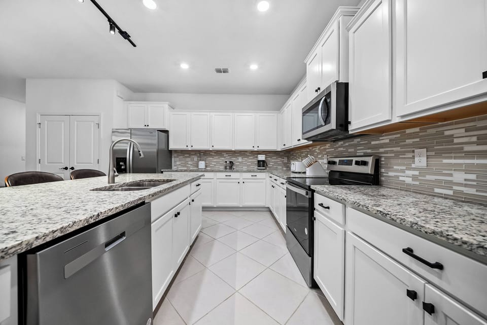 Experience a stunning kitchen with elegant white cabinetry and granite countertops that inspire your cooking. It features modern stainless steel appliances and a bright, spacious layout, ideal for meal prep and gatherings with.