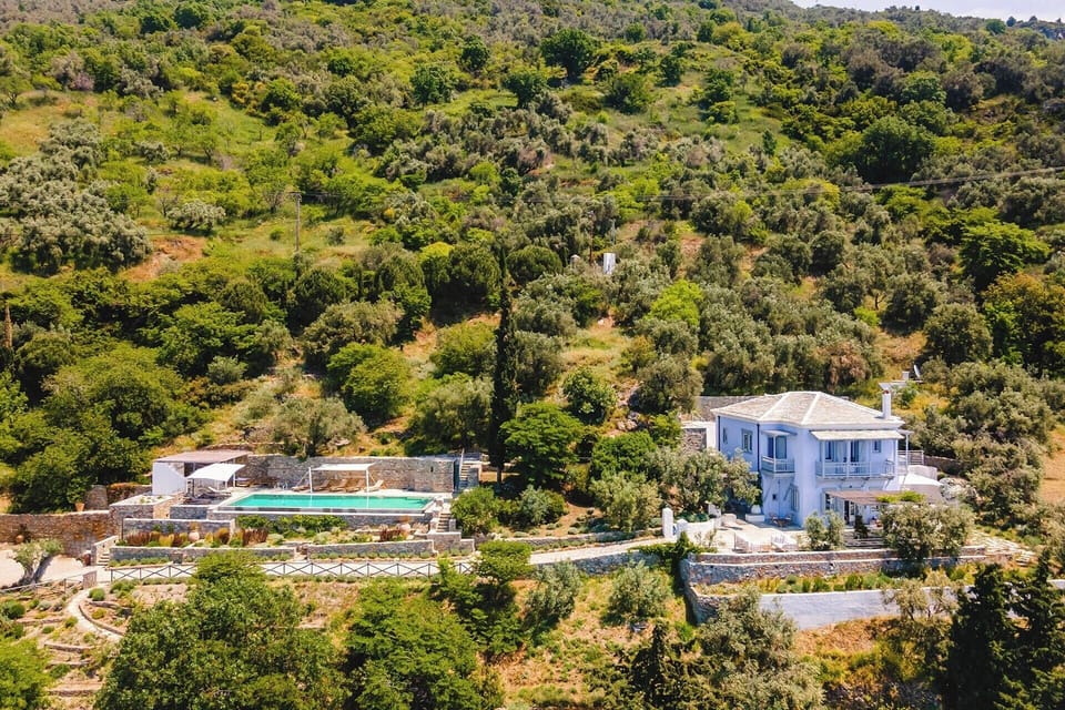 Blue House rising serenely on the verdant coastline of northwest Skopelos.