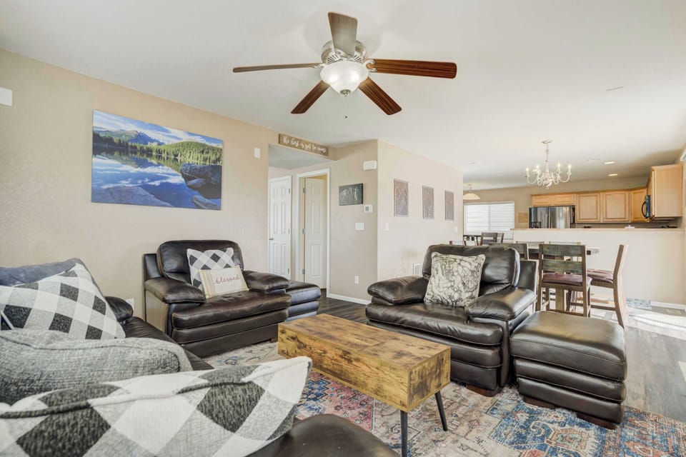 This open-concept living space provides a seamless transition into the dining and kitchen areas, allowing for easy socializing. The neutral decor and patterned area rug create a warm, inviting atmosphere for relaxation.