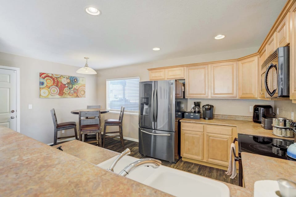 The full kitchen features warm wood cabinetry and professional-grade appliances for the home chef. An open layout and dedicated coffee station near the large refrigerator ensure you have everything needed for a stay.