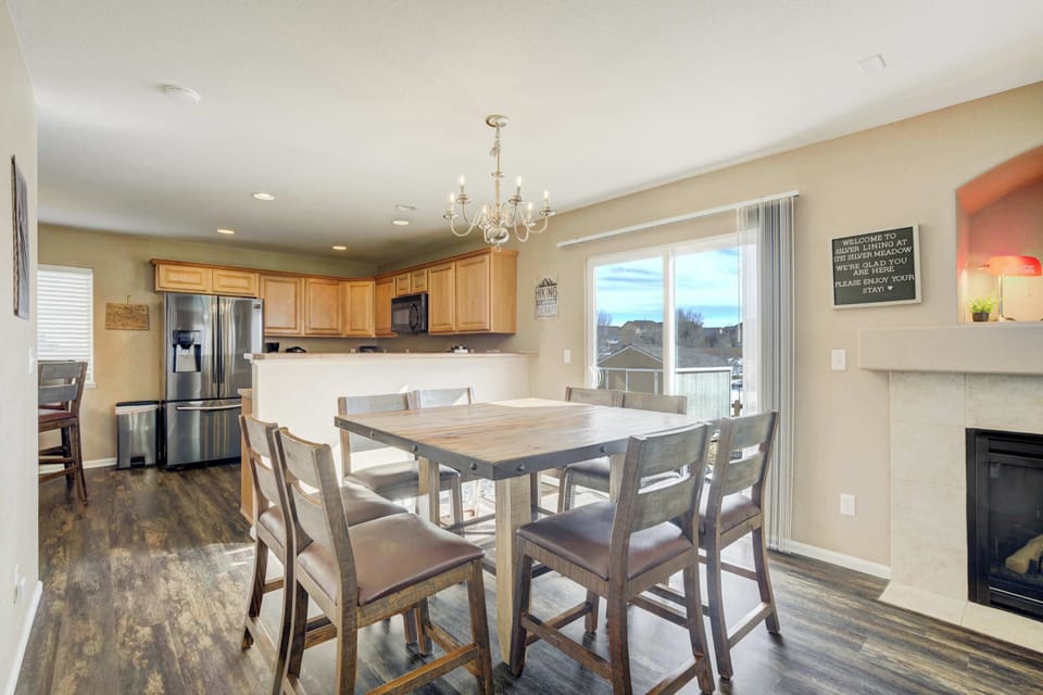 The main dining area is perfectly positioned between the kitchen and living room for effortless entertaining. A large wooden table with seating for eight sits beneath a classic chandelier, offering a bright spot for shared meals.