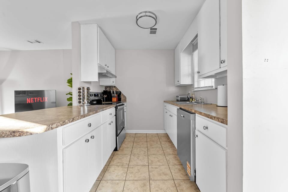 Modern kitchen with stainless steel appliances and granite-style counters—perfect for long-term meal prep.