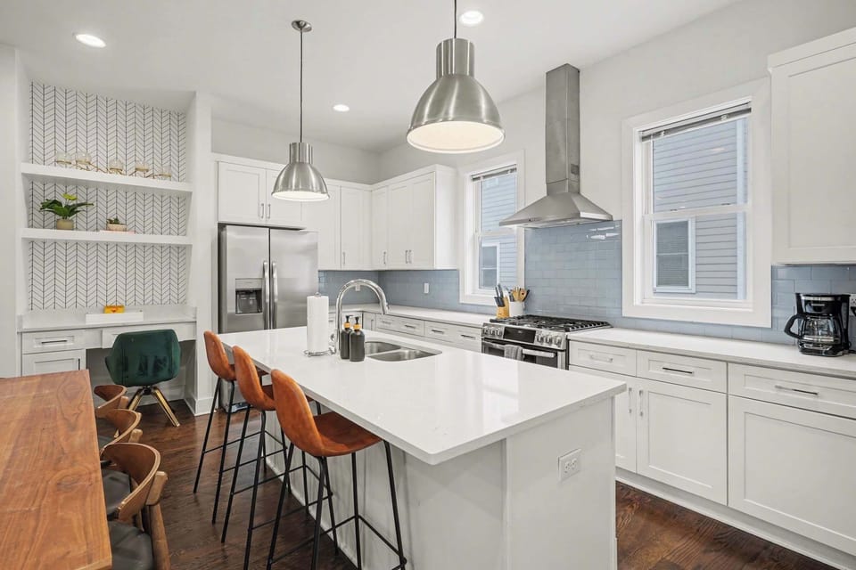 Open-concept kitchen with quartz counters, gas range, and stainless appliances. | Unit B