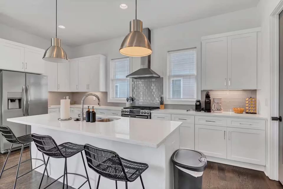 Open-concept kitchen with quartz counters, gas range, and stainless appliances. | Unit A