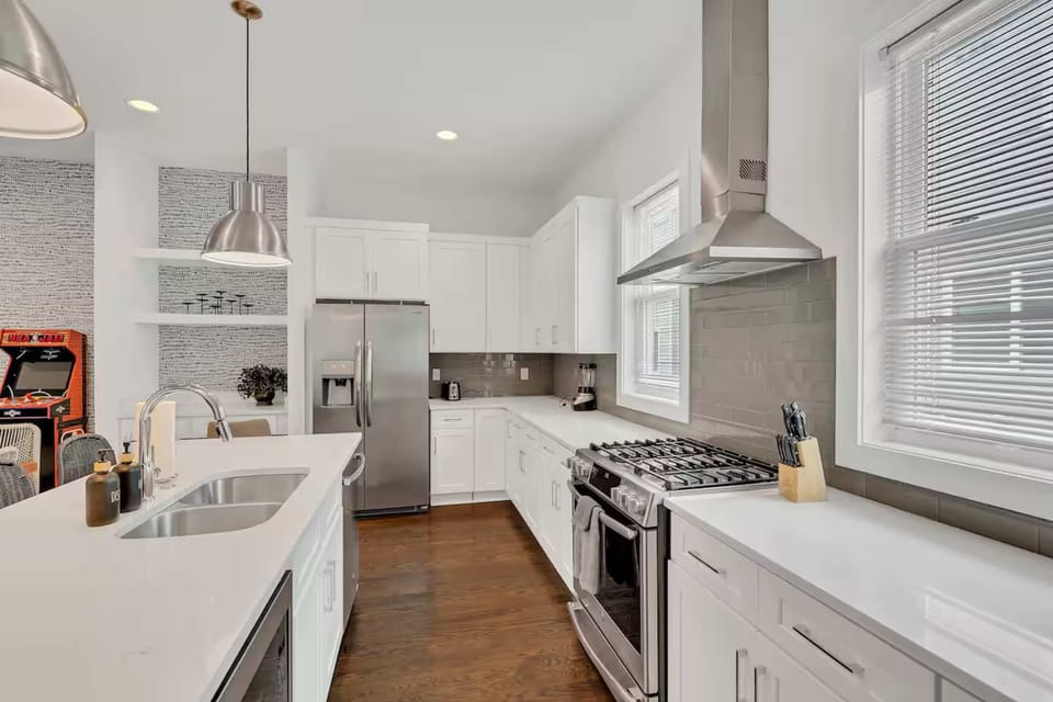 Open-concept kitchen with quartz counters, gas range, and stainless appliances.