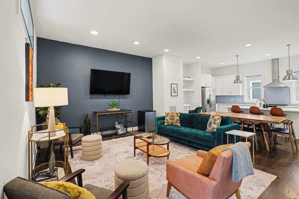 Open-concept living room with plush seating, large windows, and a chef's kitchen.