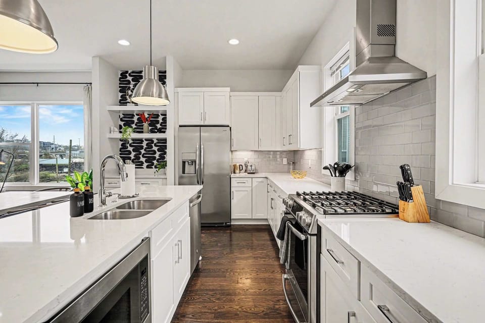 Open-concept kitchen with quartz counters, gas range, and stainless appliances.