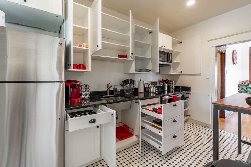 Kitchen with plates, utensils, cups, spices, Keurig, tea & all you need to dine.