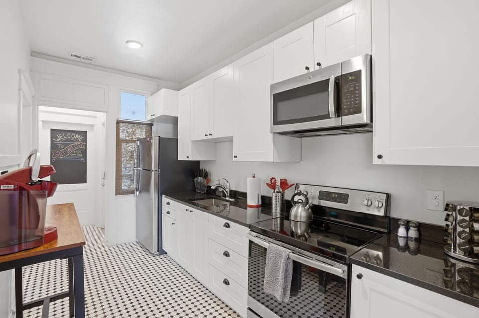 Stocked kitchen with plates, utensils, cups, and all you need to dine. 
