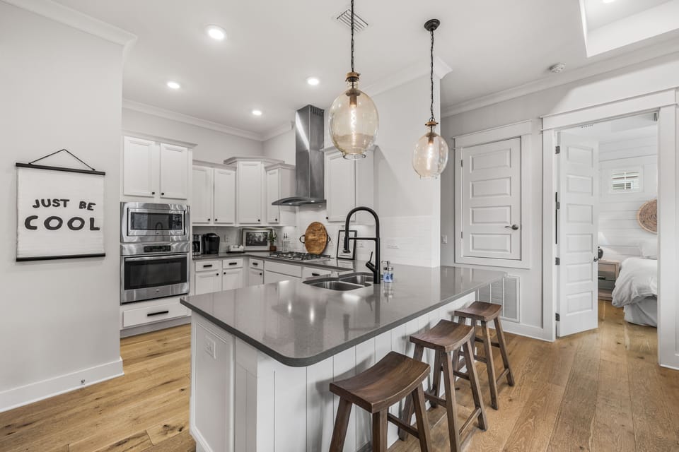 Modern kitchen with stainless steel appliances, a full-size oven, built in microwave  and a breakfast bar with stool seating - perfect for morning coffee or casual meals.