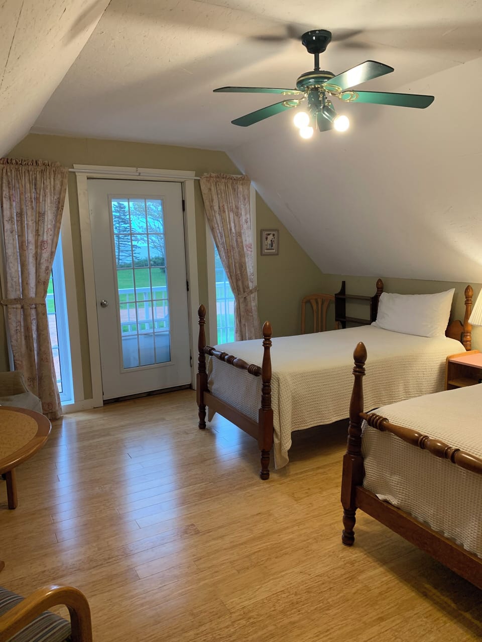 Barn 5 is an upper level bedroom with two single beds, a balcony with water view, AC, and a refrigerator