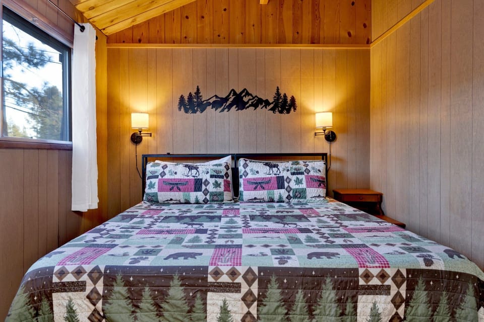 Peaceful cabin bedroom with plush bedding, and beautiful views—ideal for restful nights, cozy mornings, and a relaxing mountain escape.