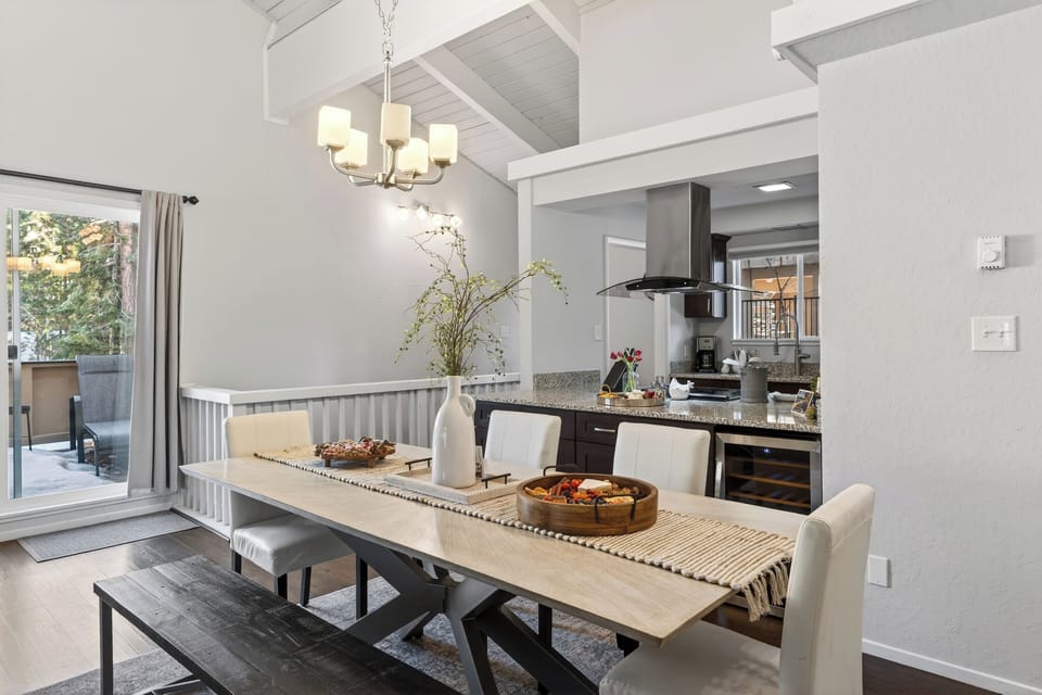 Dining area perspective showing the kitchen's stainless steel range hood.
