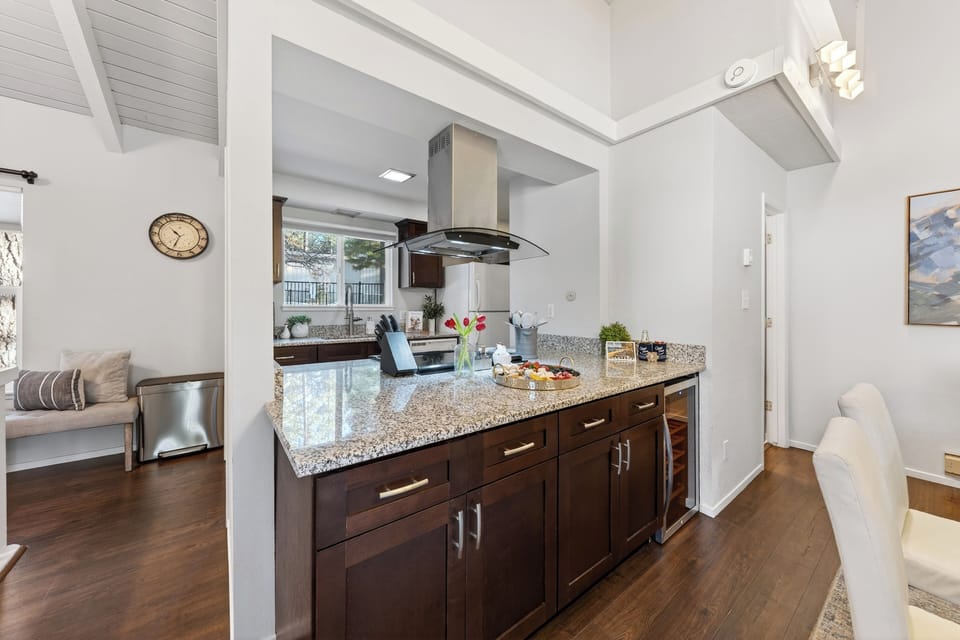 Modern kitchen featuring dark wood cabinetry, granite countertops, and stainless steel appliances.