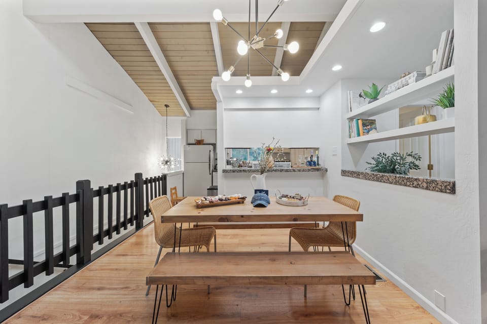 Open dining space with a long wooden table and modern lighting.