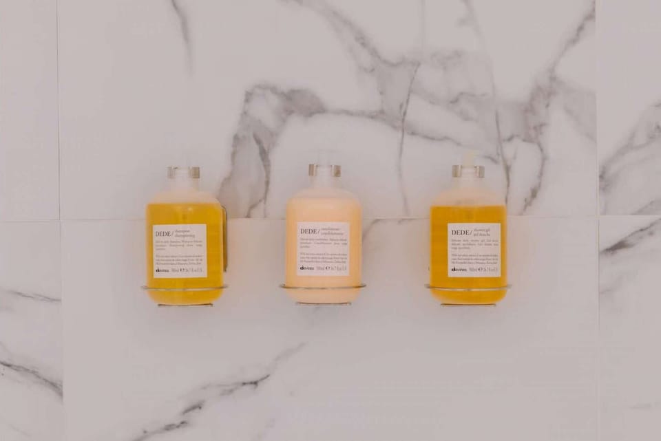 Wall-mounted bath amenities aligned on marble tile