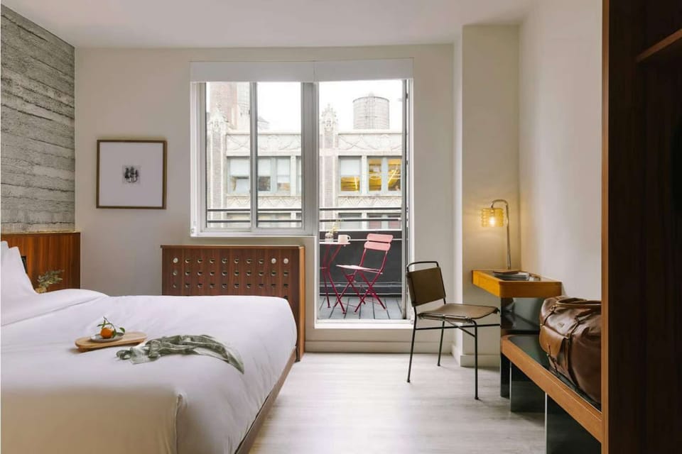 Bedroom with balcony doors, desk chair, and exterior seating