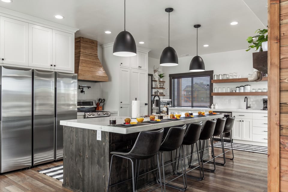 Opposite the island, a striking oversized range and oven with a pot filler are paired with dual massive refrigerators. Built for serious cooking and entertaining, this kitchen delivers bold design and high-end performance.