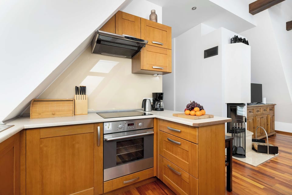 Another angle of the kitchen showing cabinets, stove, and countertop space. The room combines modern appliances with warm wooden finishes.