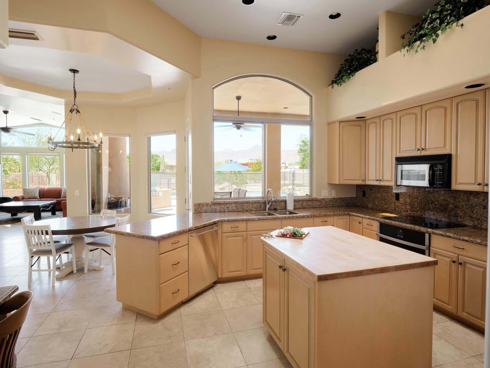 Fully equipped kitchen with stainless steal appliances, a kitchen island, ample counter space, dedicated work space, and breakfast nook.