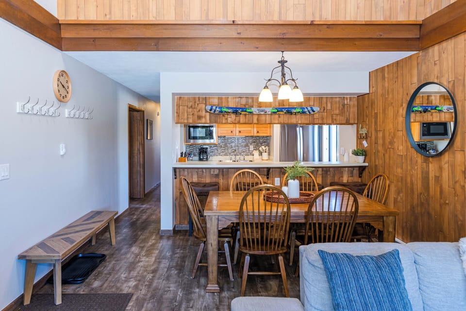 Gather around your rustic dining table for memorable meals in this open-concept space featuring warm wood beams and fully equipped kitchen.