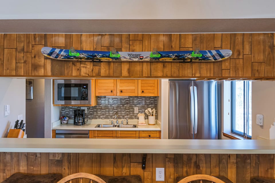 Your fully-equipped kitchen features modern appliances and warm wood accents, perfect for preparing meals during your mountain getaway.