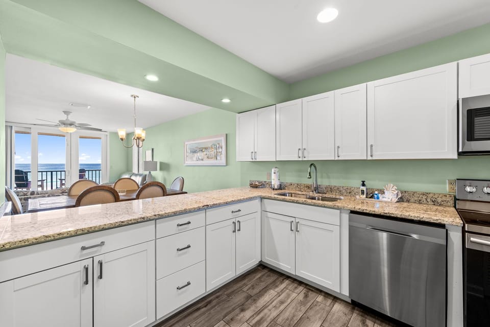 Bright, modern kitchen w/ granite counters, stainless appliances & ocean views to inspire every meal.