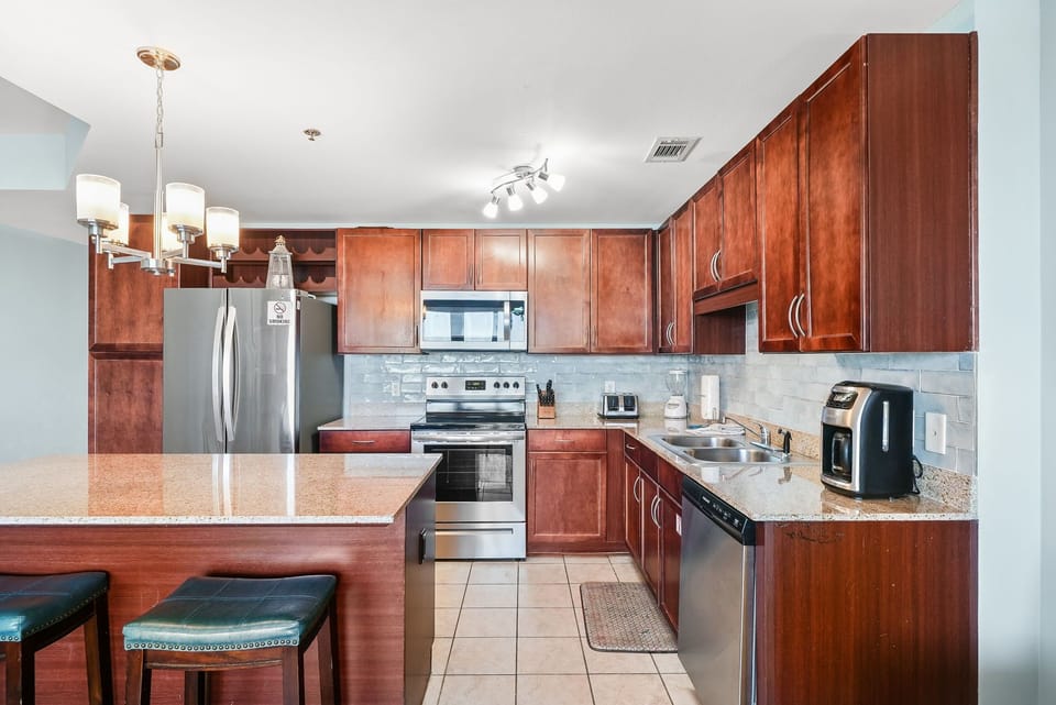 Modern kitchen with stainless steel appliances and a spacious island for dining.