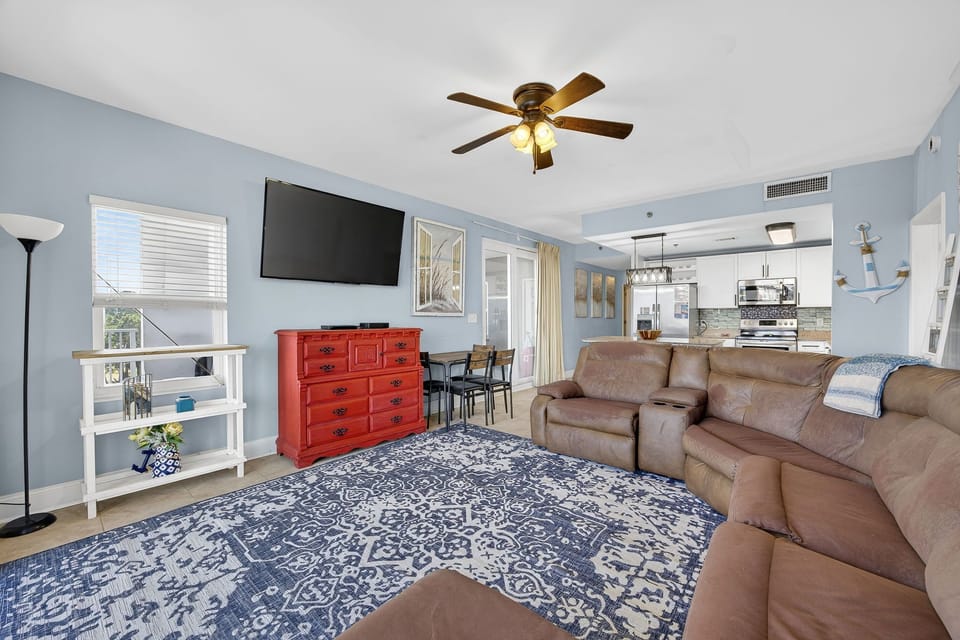 Spacious living area with a large sectional sofa and wall-mounted television in a modern open-concept design.