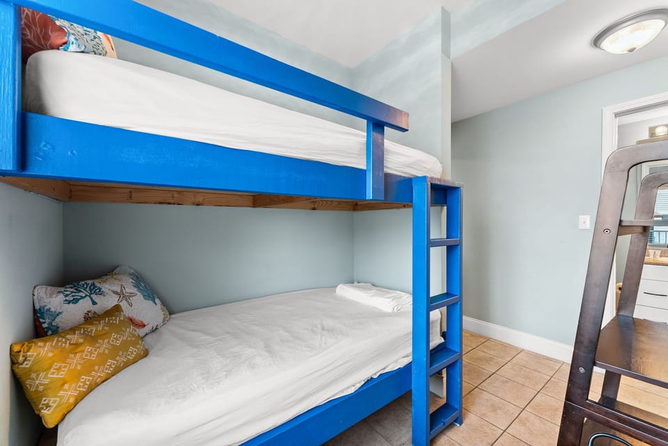 Cozy bunk bed with bright blue frame in a light-filled room