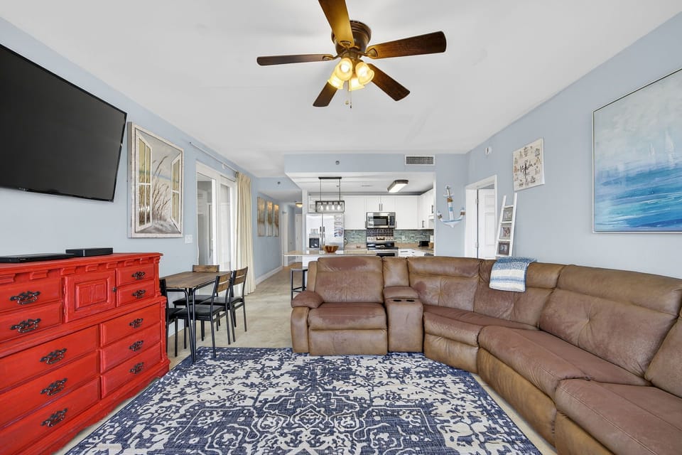 Spacious living area with a large sectional sofa and open kitchen in the background