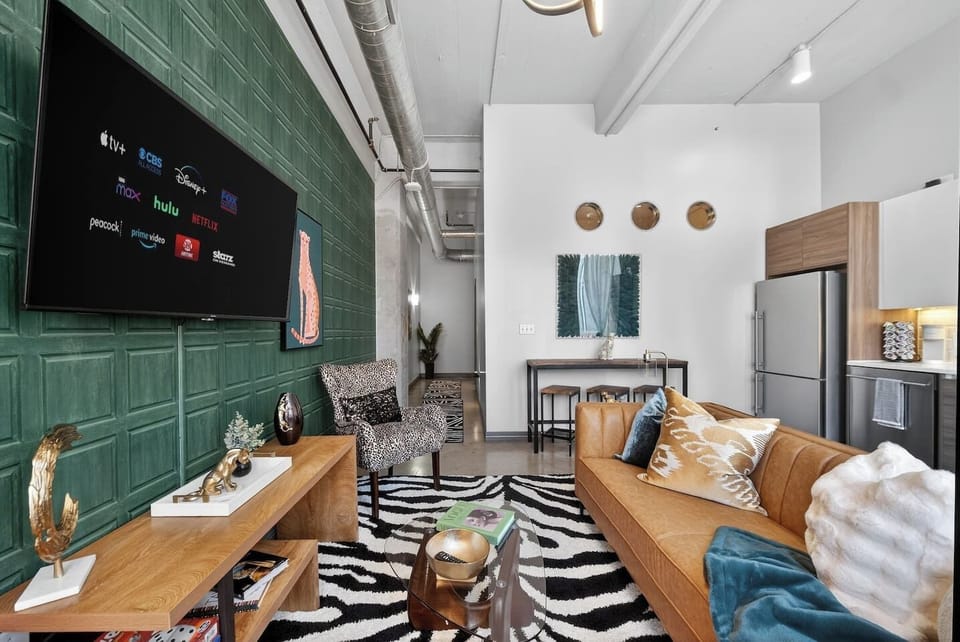 Living Room: Open-concept living space with designer furnishings, smart TV, and seamless flow to kitchen and dining—ideal for relaxing or entertaining.