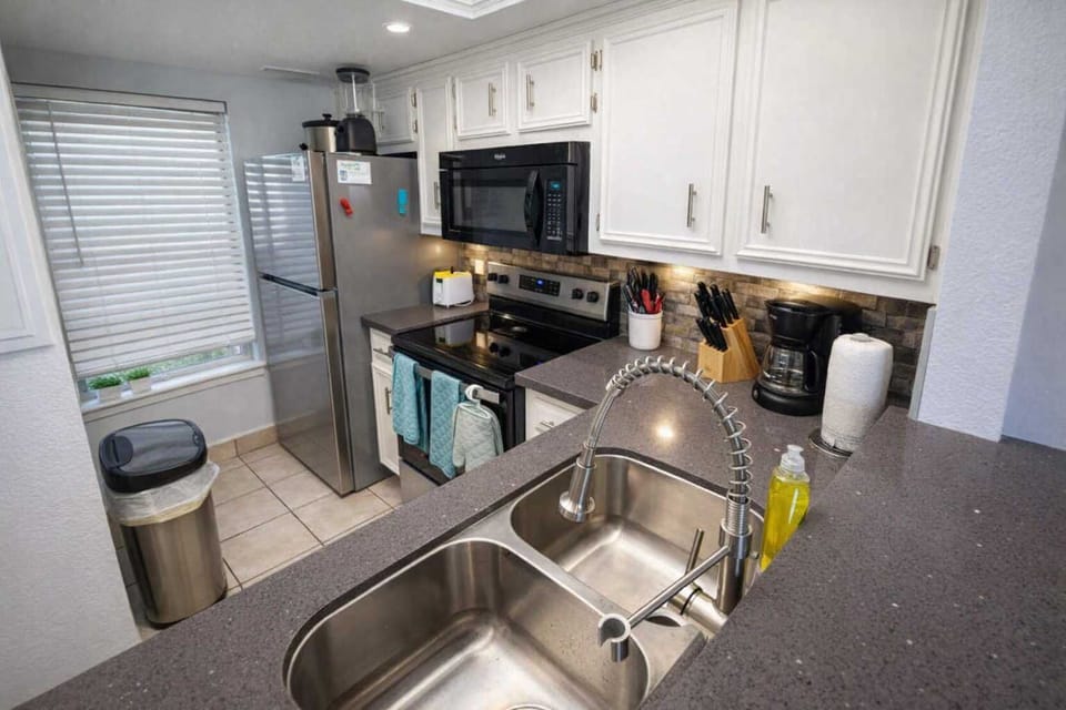 Modern Kitchen with Stainless Steel Appliances, Coffee Station, and Bright Natural Light – Perfect for Short-Term Stays