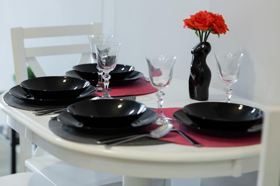 Elegant table setting with flowers and dark tableware.
