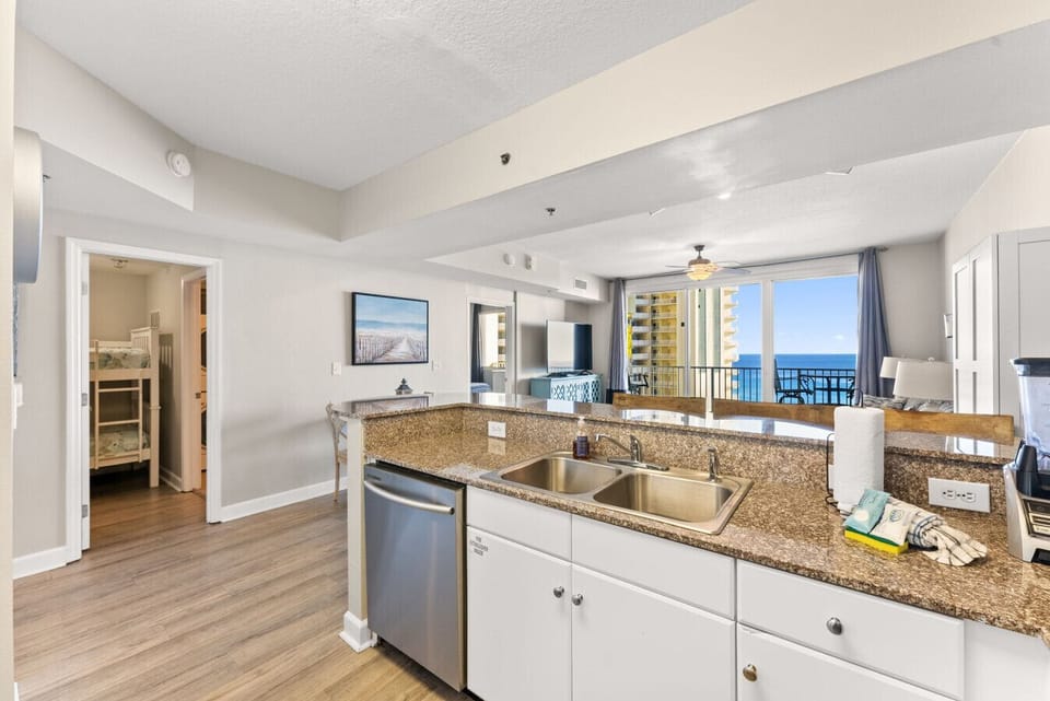 Open kitchen with breakfast bar overlooking the living room and Gulf-view balcony.