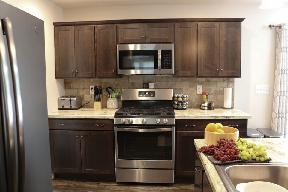 This kitchen has a fridge, stove, dishwasher, and microwave.