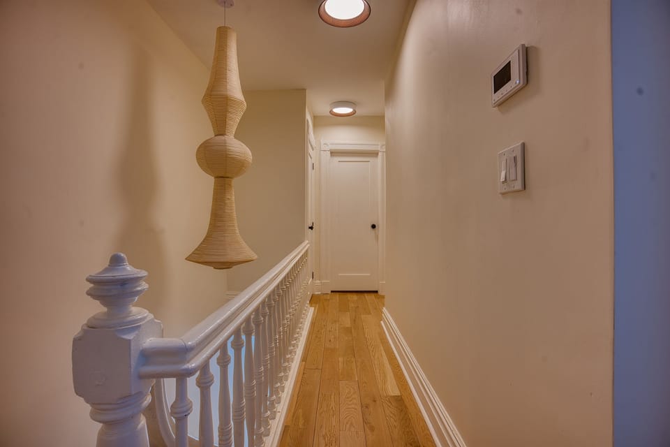 The hallway of the top floor of duplex. Here you will find two bedroom with their own bathrooms, as well as washer and dryer behind sliding doors. 