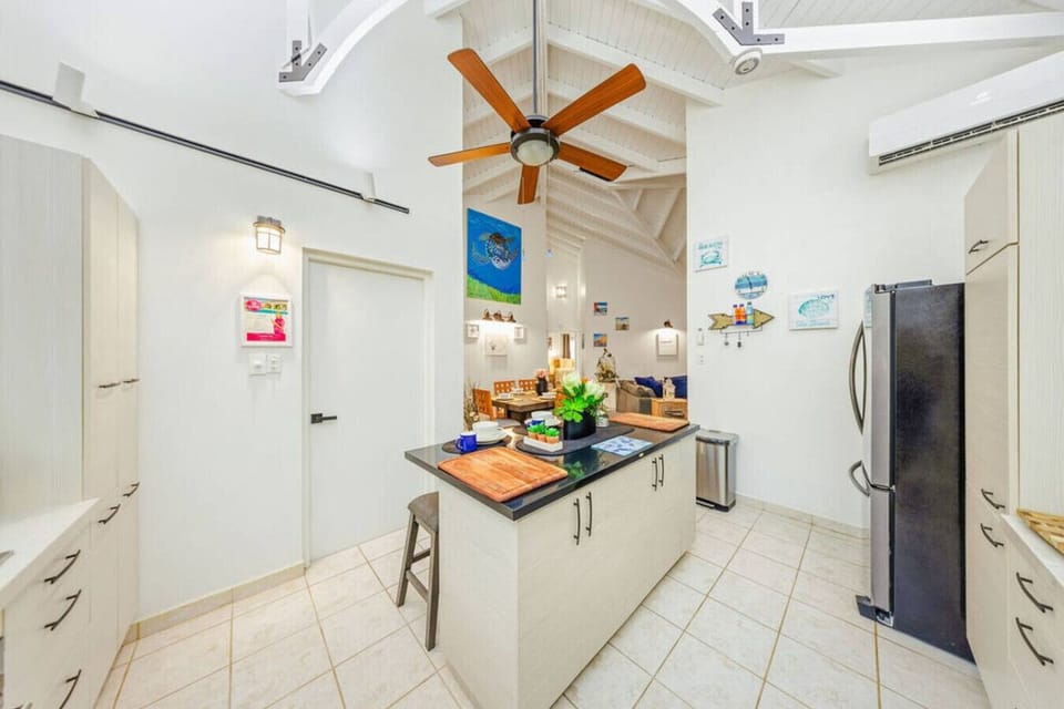 The heart of the villa! Gather around the central island for snacks and drinks while staying connected to friends and family in the open-concept living and dining areas.