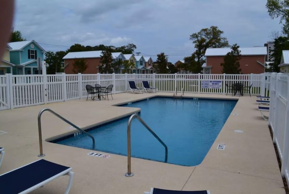 Community pool with loungers just steps from the house