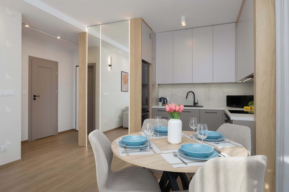 Stylish dining corner with round table and elegant place setting.