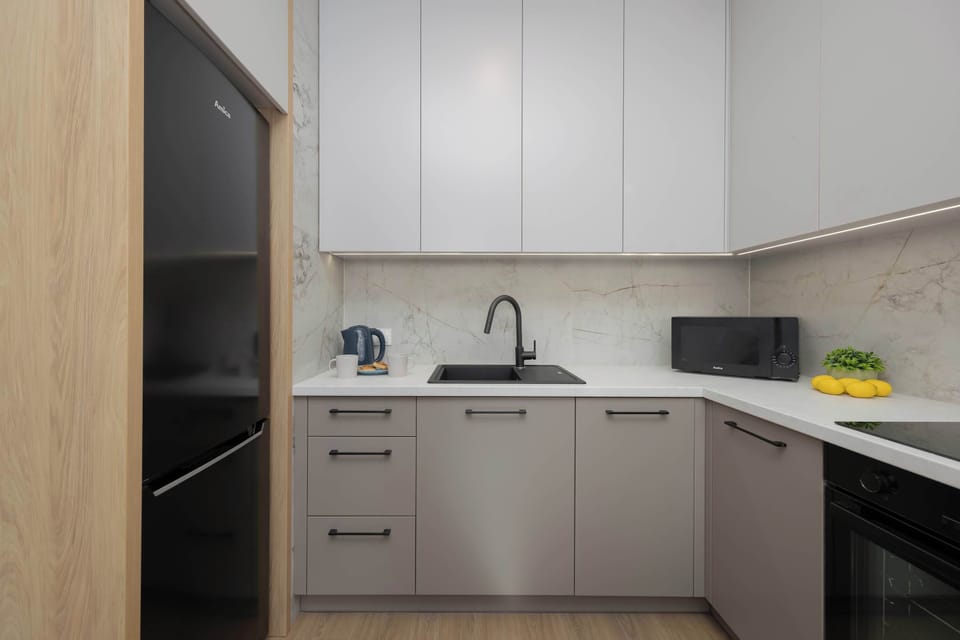 Modern kitchenette with light cabinetry, clean lines, and practical workspace.