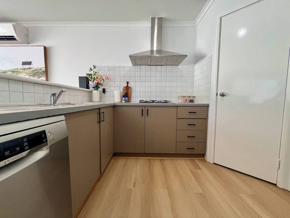 Modern, fully-equipped kitchen featuring a sleek range hood, integrated dishwasher, and ample counter space for effortless meal preparation