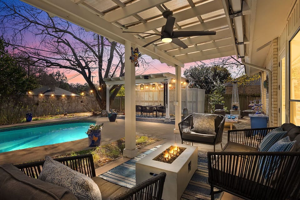 Unwind on the covered patio with cozy seating, string lights, and relaxing backyard vibes — perfect for San Antonio evenings.
