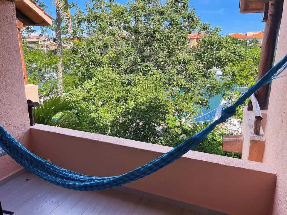 “Descansa en la hamaca frente a la marina y siente la brisa tropical mientras disfrutas de la tranquilidad de Puerto Aventuras.”