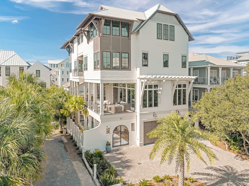 Stunning coastal architecture featuring modern beach house design with elevated construction and tropical landscaping in a desirable neighborhood setting.