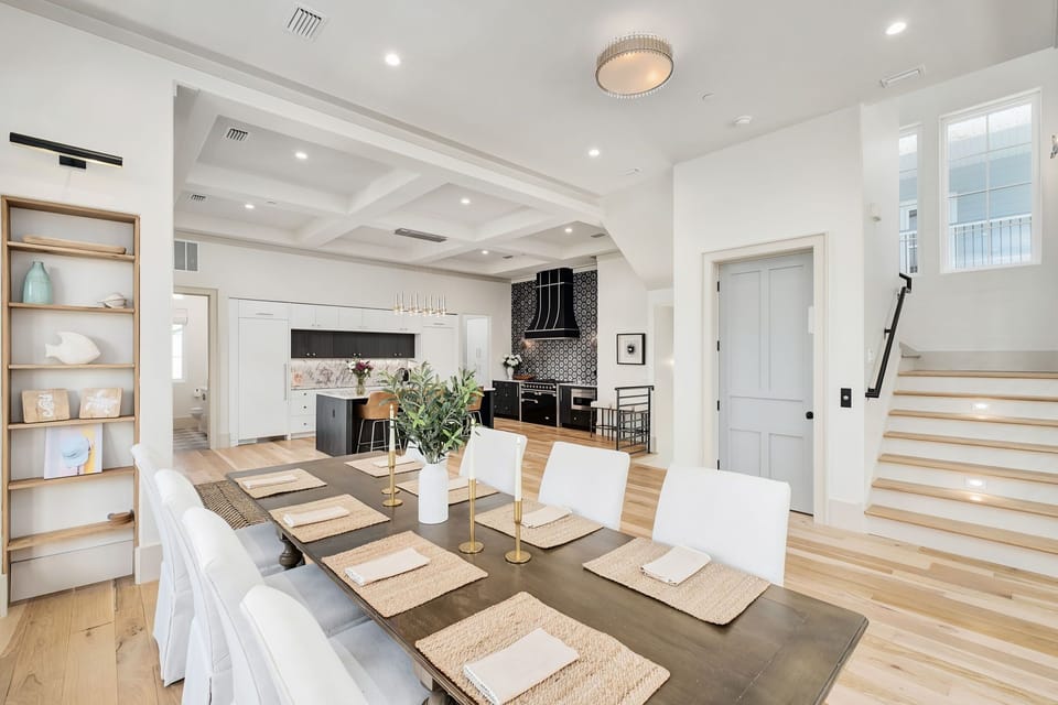 Gather around this stunning dining table where memorable meals unfold beneath soaring coffered ceilings and elegant lighting.