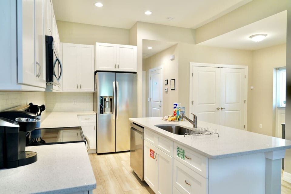 White granite island with faucet and stainless steel appliances.