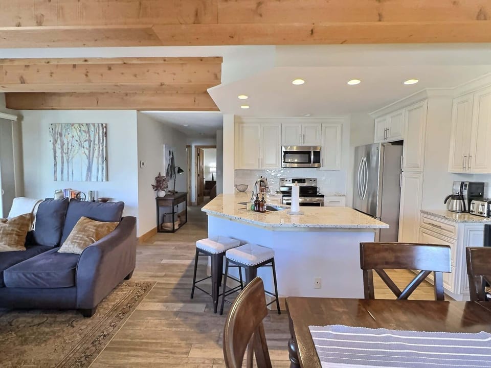  kitchen and living area, featuring wooden ceiling beams and tiled floors
