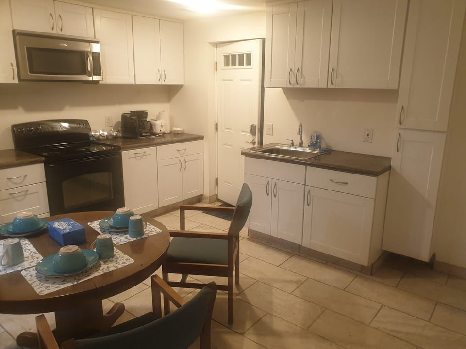  coffee and or coffee maker, kitchen, oven, stovetop, dining table, microwave,