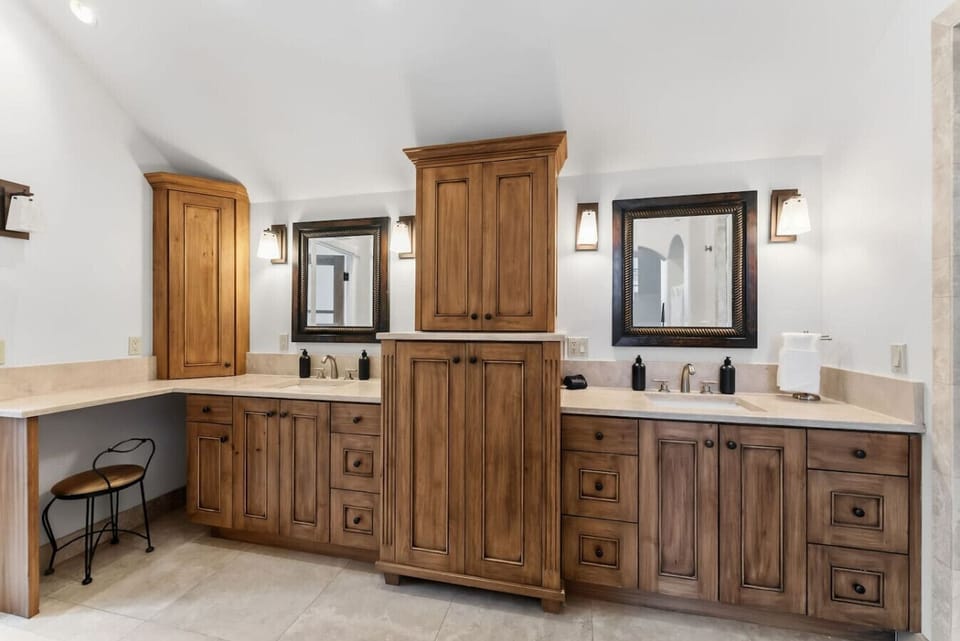 Primary bedroom with king bed, double sided fireplace, smart TV, and spa-like en suite bathroom